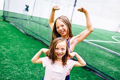 Two young girls posing for a photo at the Crosslink County Sportsplex fieldhouse